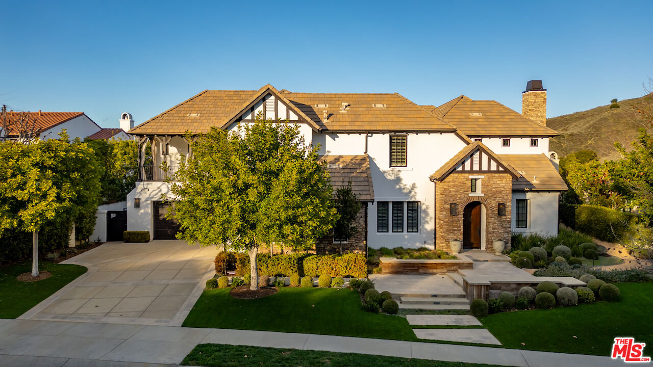 a view of a white house with a yard and plants