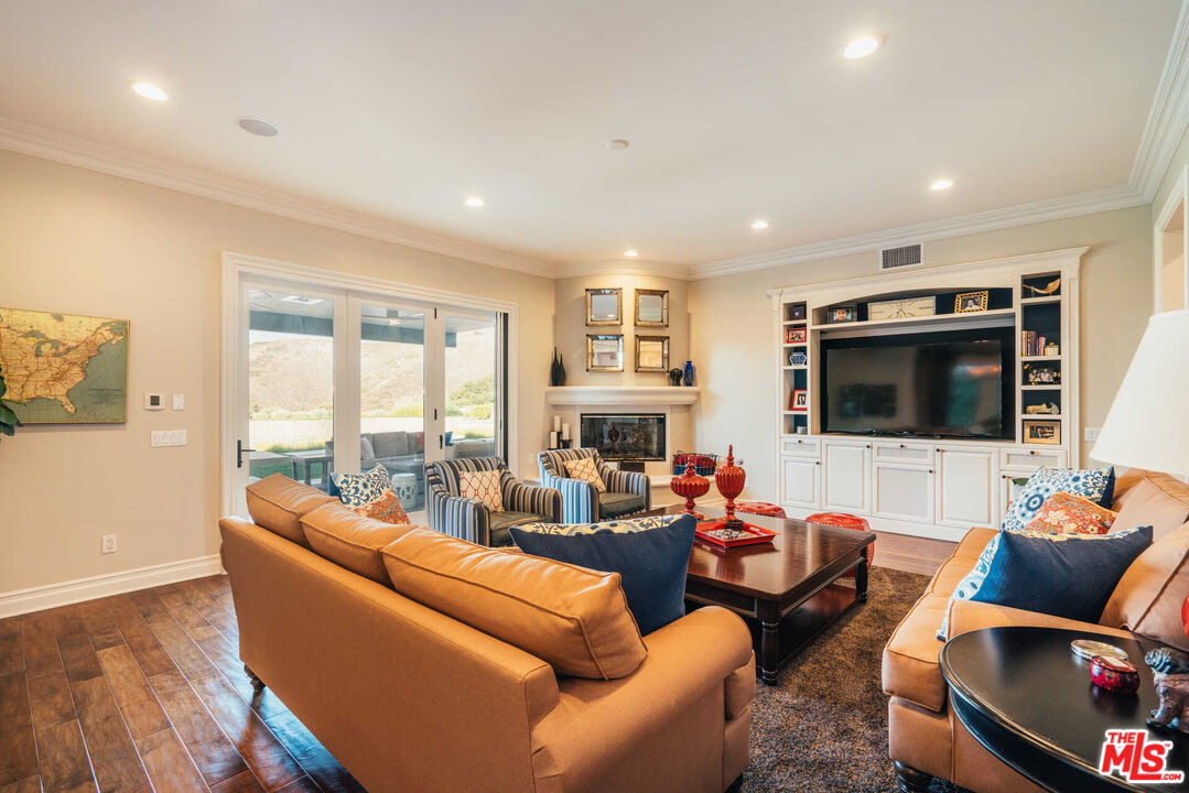 25311 Prado De Ambar Calabasas, CA 91302 - Photo 28 of 58 a living room with furniture fireplace and a flat screen tv
