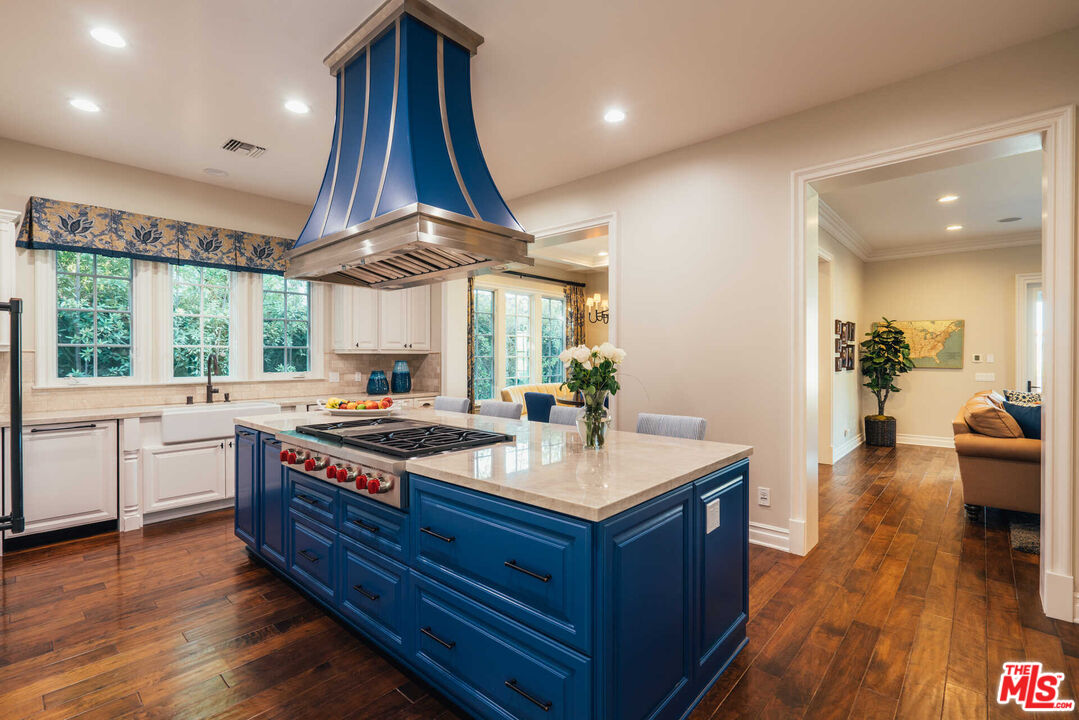 25311 Prado De Ambar Calabasas, CA 91302 - Photo 29 of 58 a large kitchen with stainless steel appliances a large counter space and wooden floors