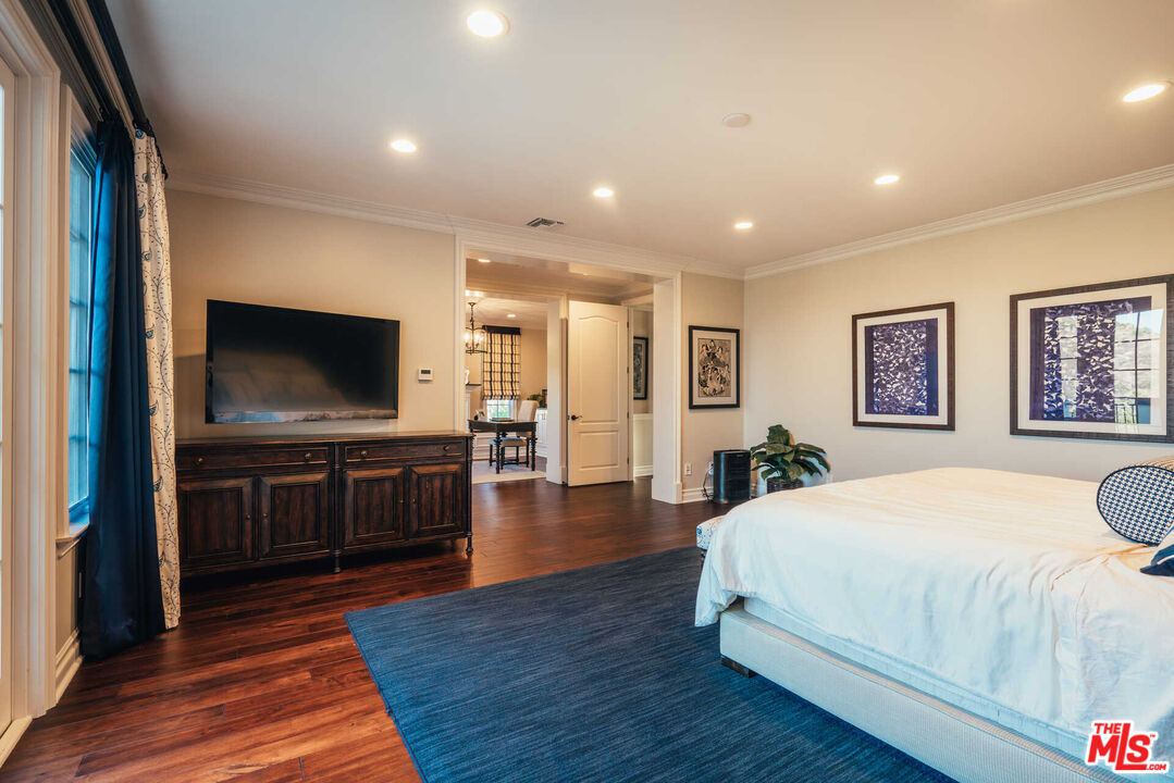25311 Prado De Ambar Calabasas, CA 91302 - Photo 48 of 58 a spacious bedroom with a bed and a flat screen television