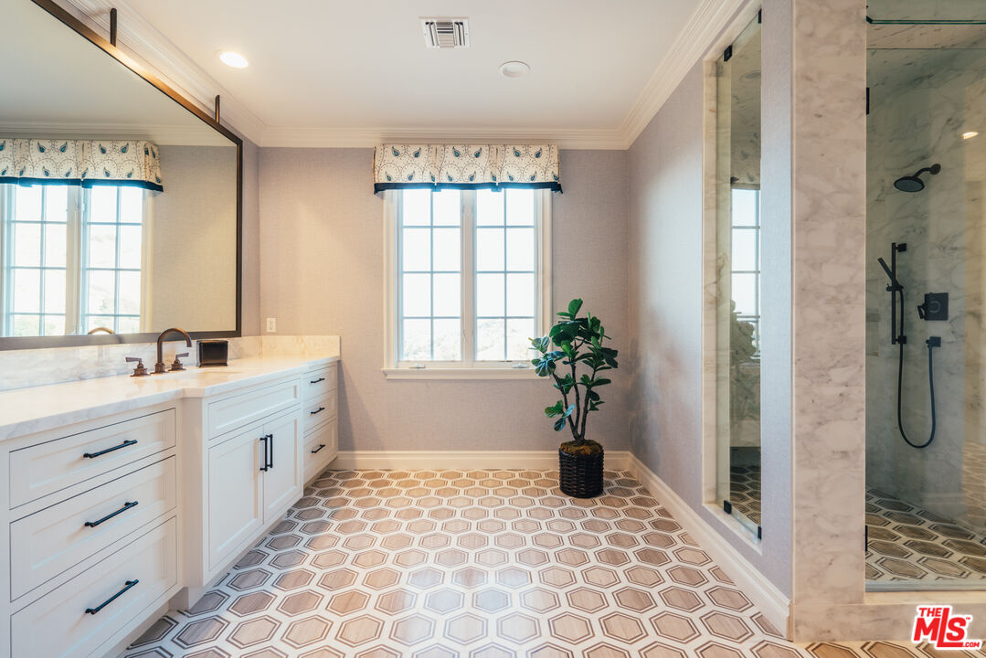 25311 Prado De Ambar Calabasas, CA 91302 - Photo 51 of 58 a bathroom with a granite countertop sink a large mirror a bathtub and next to a window