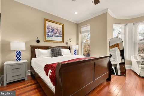 a bedroom with a large bed and a flat tv screen on dresser