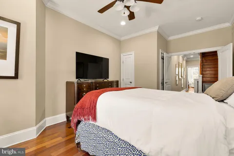 a view of a hallway with wooden floor and a living room