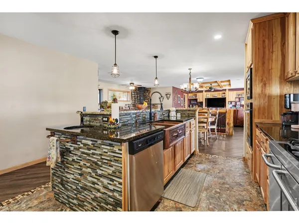 a kitchen with stainless steel appliances granite countertop a stove a sink and a refrigerator