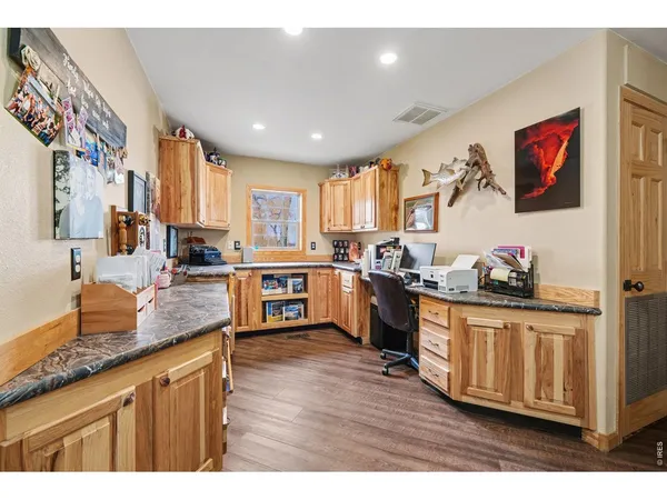 a kitchen with stainless steel appliances granite countertop a stove a sink dishwasher and a refrigerator with wooden floor