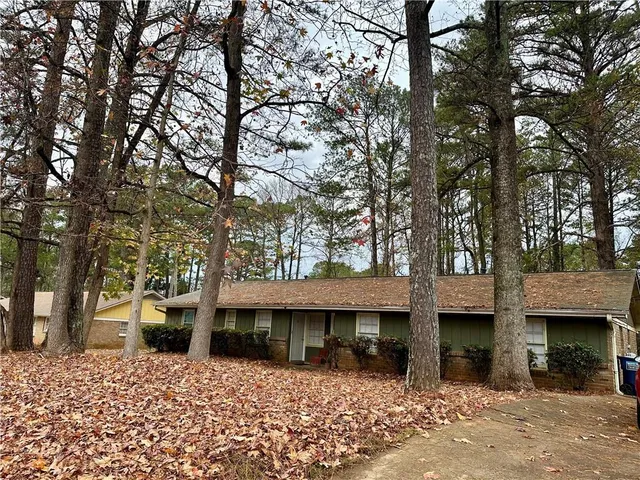 a front view of a house with a tree