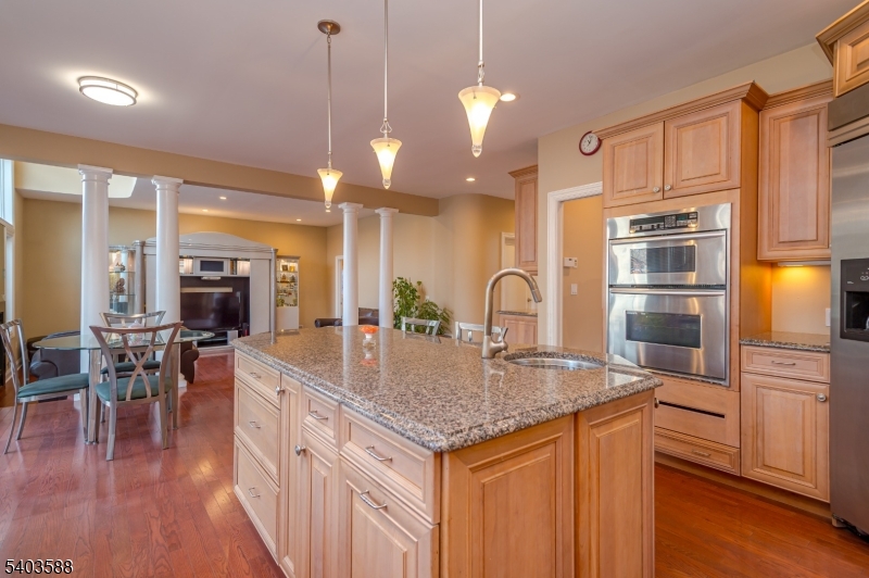53 Princeton Avenue Woodbridge, NJ 07067 - Photo 12 of 37 a kitchen with stainless steel appliances granite countertop a kitchen island a stove a sink a dining table and chairs with wooden floor