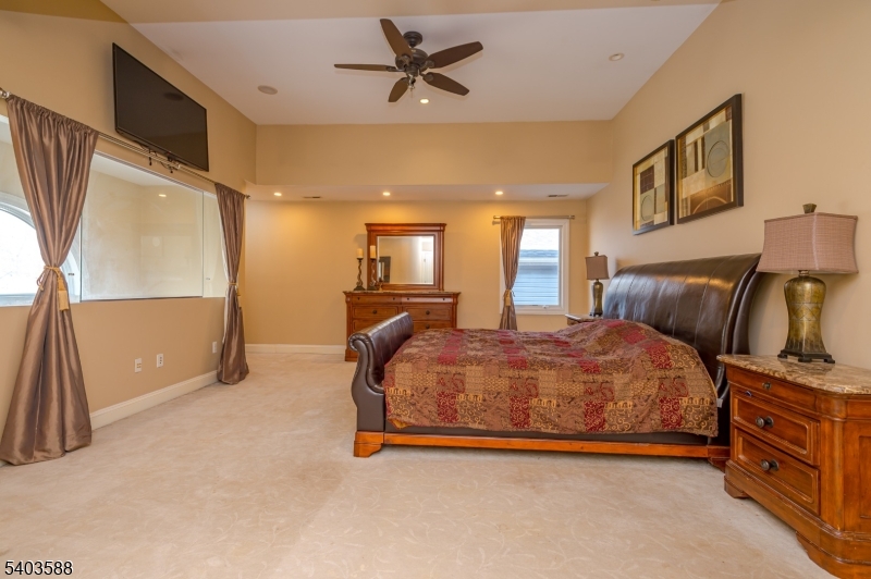 53 Princeton Avenue Woodbridge, NJ 07067 - Photo 27 of 37 a spacious bedroom with a bed and dresser with mirror