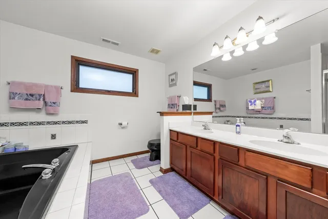 a spacious bathroom with a sink a large mirror and a shower