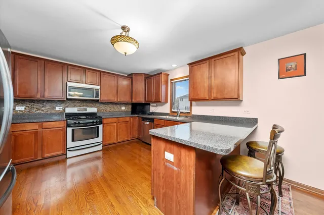 a kitchen with granite countertop wooden floors and stainless steel appliances