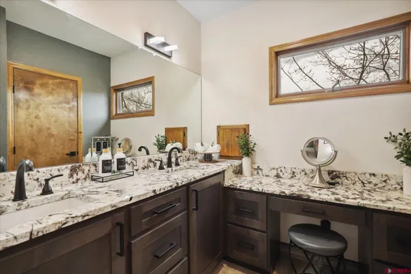 a en suite bathroom with a granite countertop sink a mirror and shower