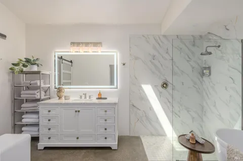 a bathroom with a double vanity sink mirror and bathtub