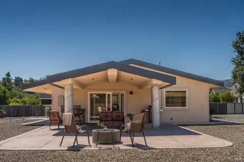 a view of the patio with table and chairs under an umbrella