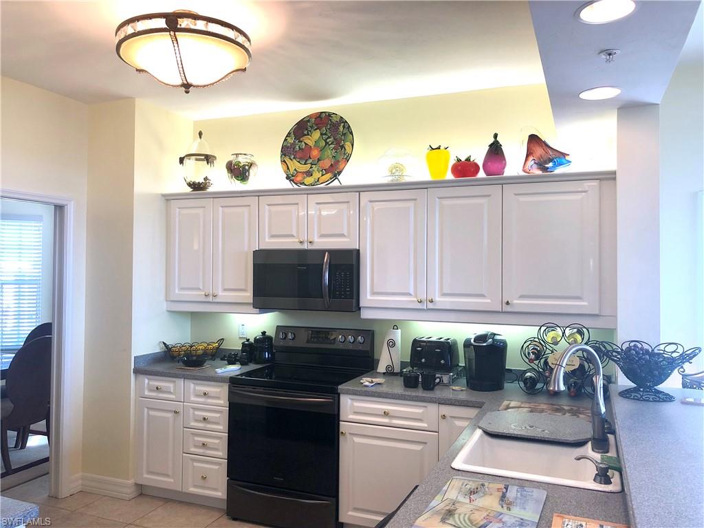 451 Bayfront Place, Unit 5311 Naples, FL 34102 - Photo 20 of 38 a kitchen with stainless steel appliances granite countertop a stove a sink and a microwave