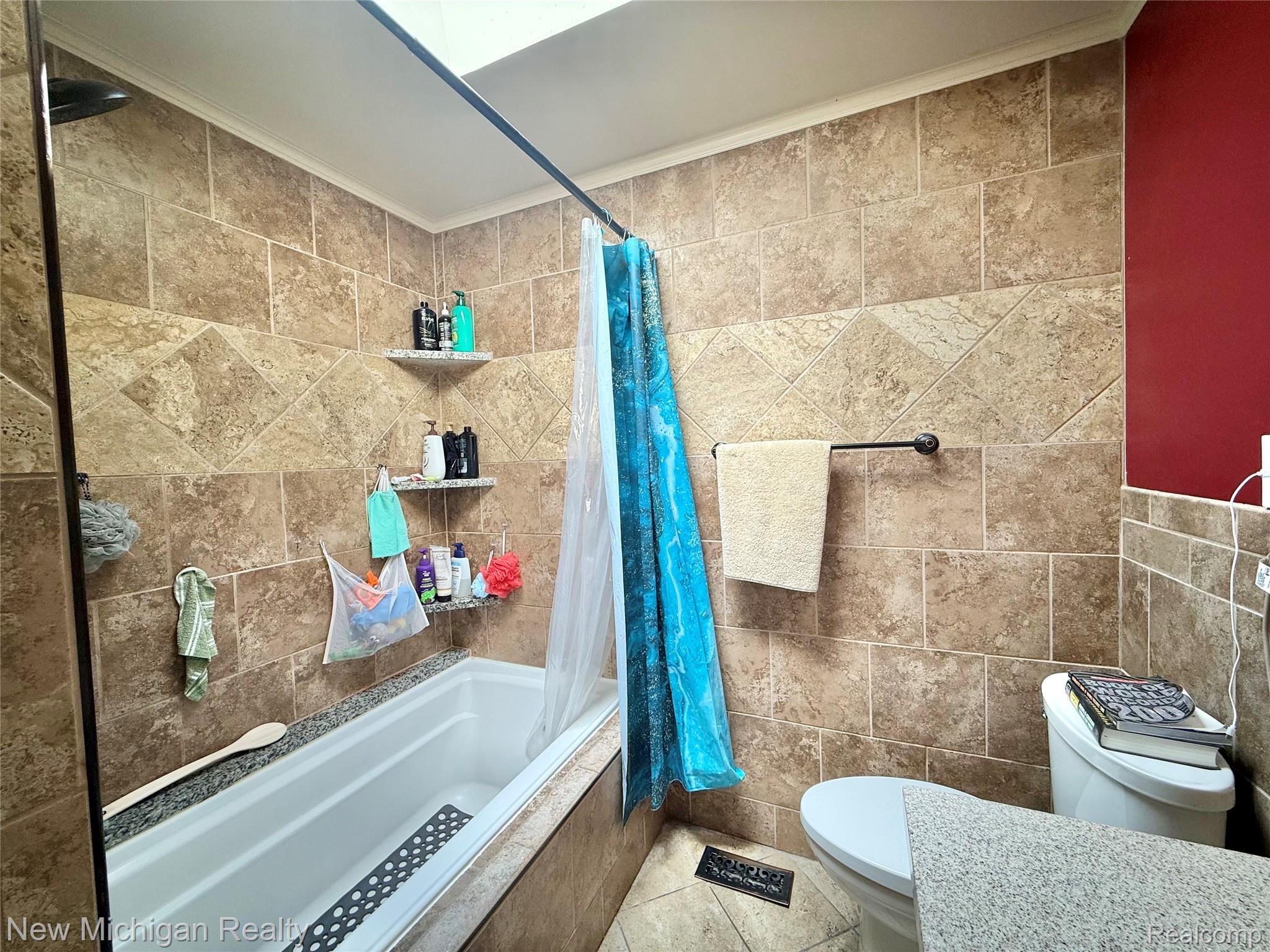 1054 Ransom Drive Flint, MI 48507 - Photo 20 of 27 Bathroom with tiled shower / bath, tile walls, crown molding, and light tile patterned floors