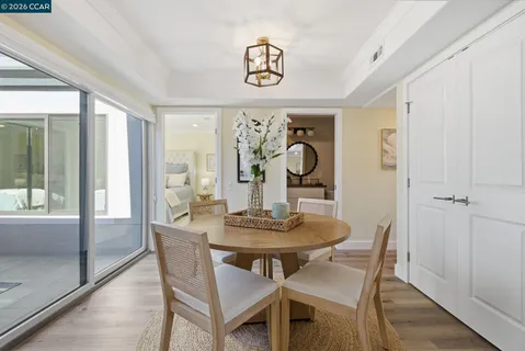 a dining room with wooden floor a chandelier a wooden table and chairs