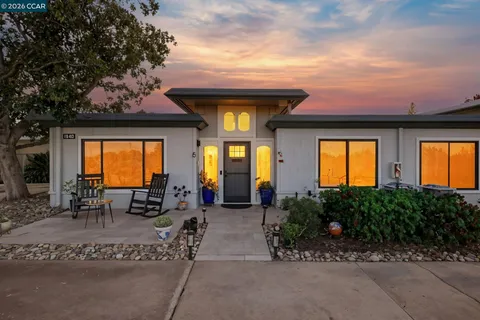 a view of a house with backyard sitting area and garden