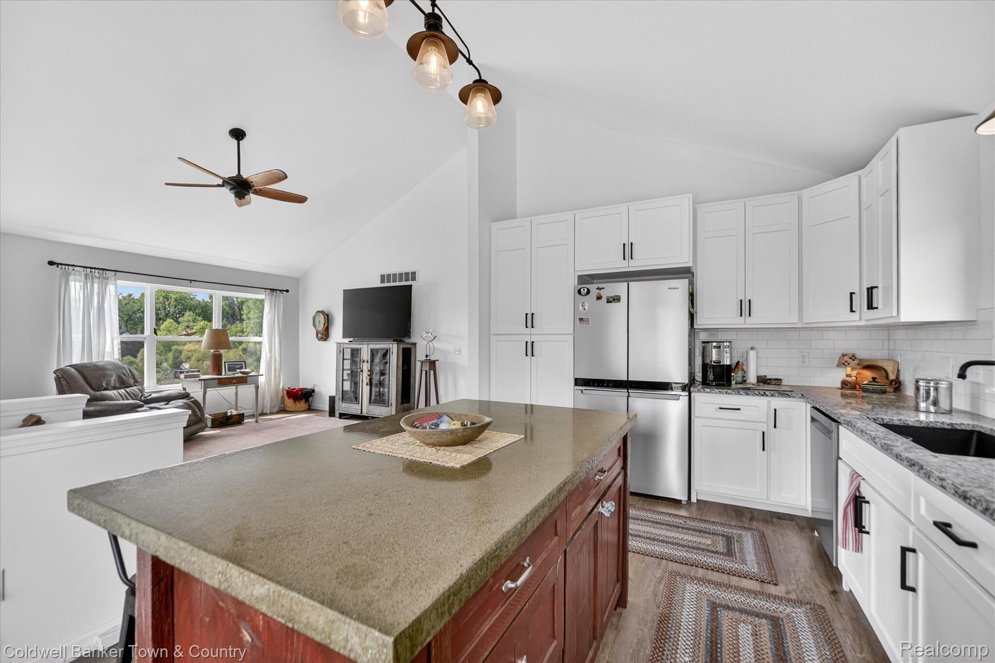 918 Gray Fox Court Howell, MI 48843 - Photo 50 of 84 Kitchen island with a durable countertop, white cabinetry with matte black hardware, stainless steel appliances, and a subway tile backsplash