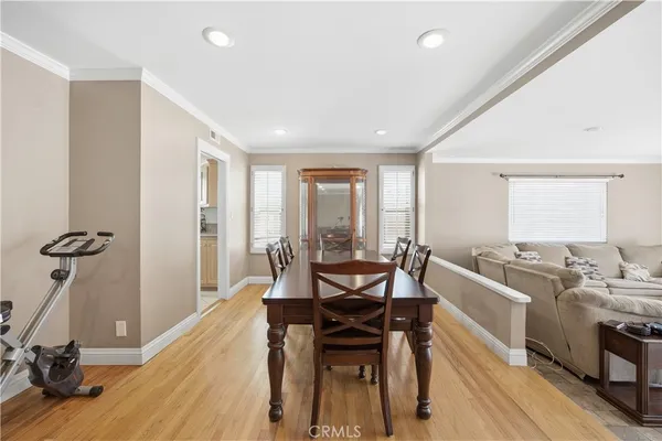 a view of a a dining room with furniture window and wooden floor