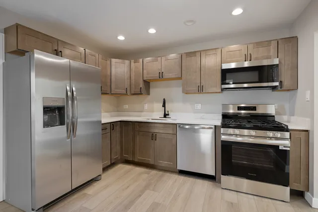 a kitchen with stainless steel appliances granite countertop a stove a refrigerator and a microwave