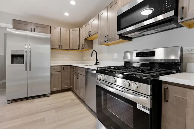 a kitchen with stainless steel appliances and wooden cabinets