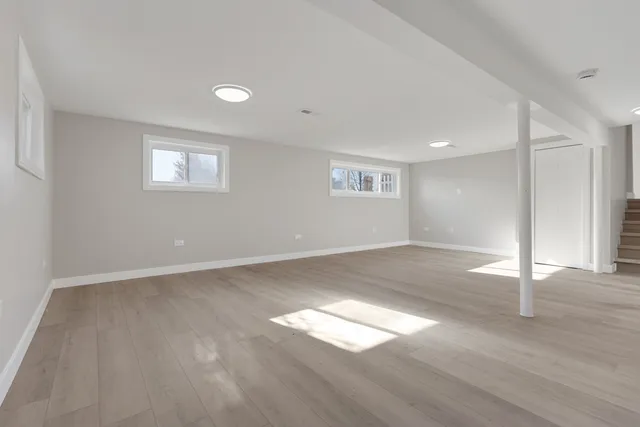 an empty room with wooden floor and window