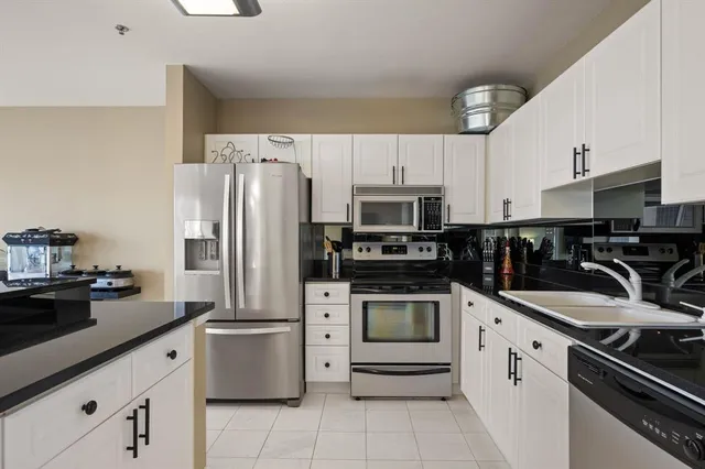 a kitchen with granite countertop a white cabinets and stainless steel appliances