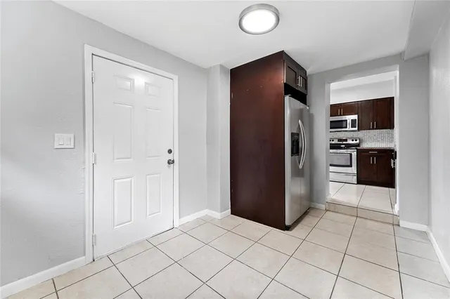 a kitchen with granite countertop a refrigerator and a stove top oven