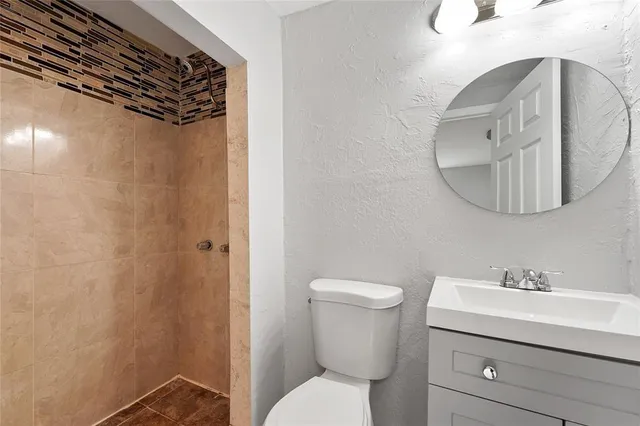 a bathroom with a toilet sink and mirror