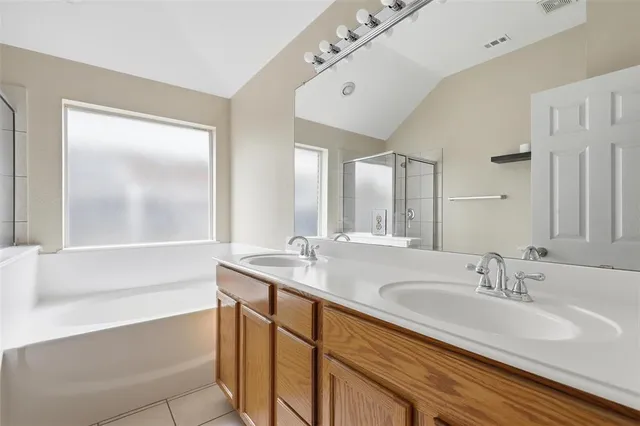 a bathroom with a granite countertop sink mirror and a bath tub