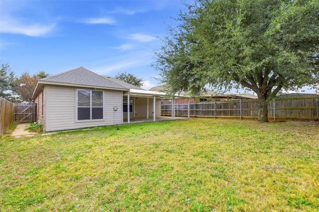 a backyard of a house with table and chairs