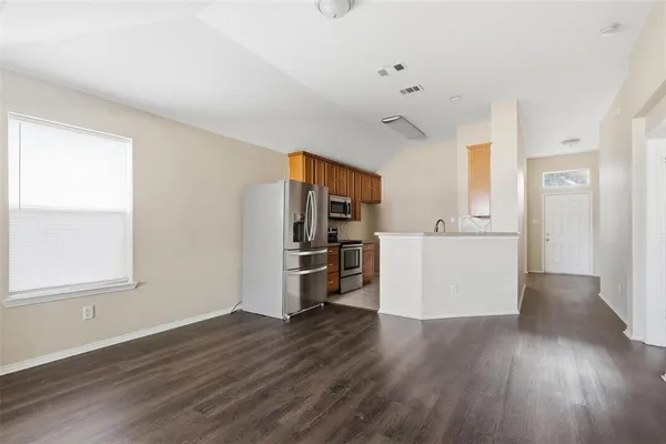 a view of a kitchen with wooden floor and electronic appliances