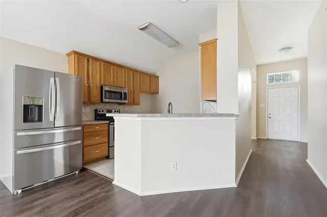 a kitchen with wooden cabinets and stainless steel appliances