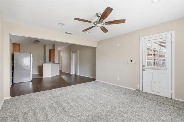 a view of a livingroom with a ceiling fan and wooden floor
