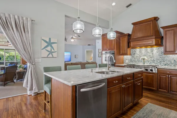 a kitchen with a sink a counter space and a view of living room