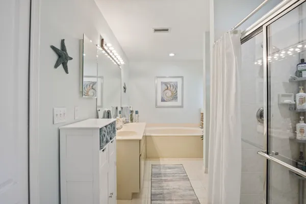 a bathroom with a tub sink and mirror
