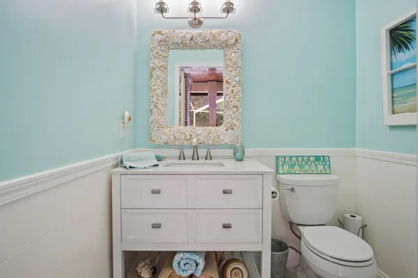 a bathroom with a granite countertop toilet sink and mirror