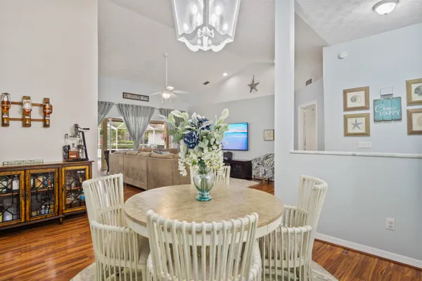 a dining room with furniture a chandelier and wooden floor
