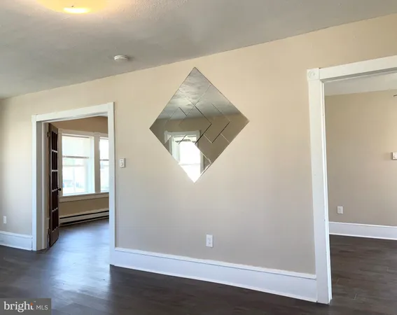 an empty room with wooden floor and a window