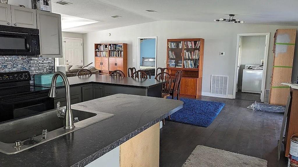 4402 Gallagher Road Plant City, FL 33565 - Photo 15 of 42 a kitchen with stainless steel appliances granite countertop a sink a stove top oven a counter space and cabinets