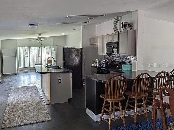 4402 Gallagher Road Plant City, FL 33565 - Photo 17 of 42 a kitchen with stainless steel appliances kitchen island granite countertop a dining table chairs and a refrigerator