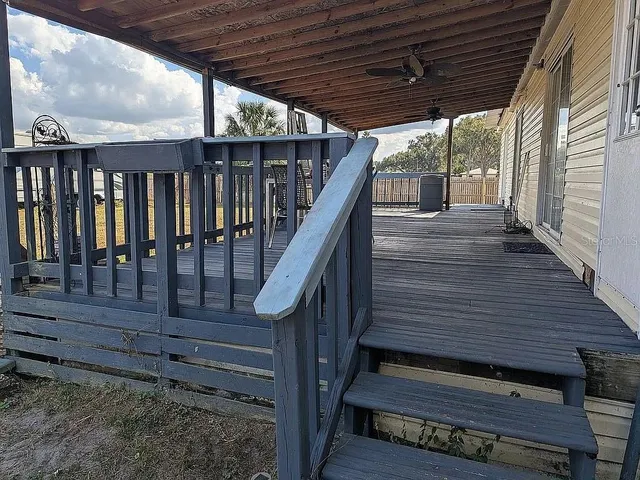 a view of a house with a yard and a large tree