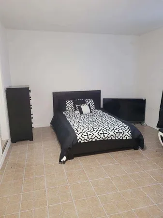 a view of a bedroom with wooden floor and bathroom