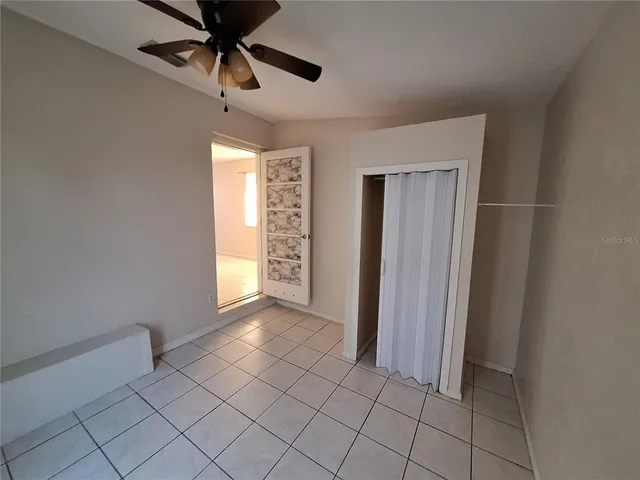 a view of empty room with window and ceiling fan