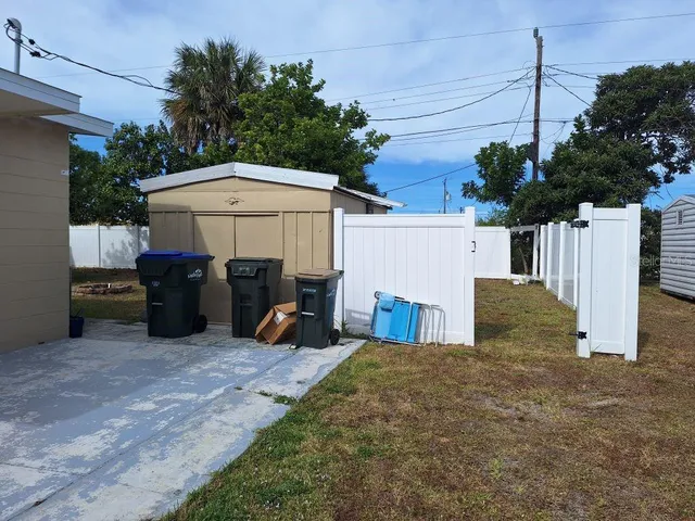 a view of a chairs and table in the back yard of the house