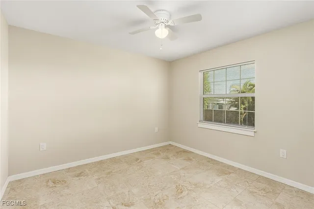 an empty room with a window and a fan