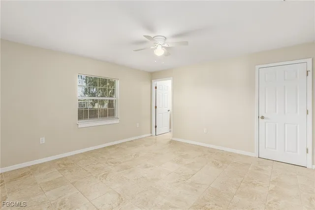 an empty room with windows and fan