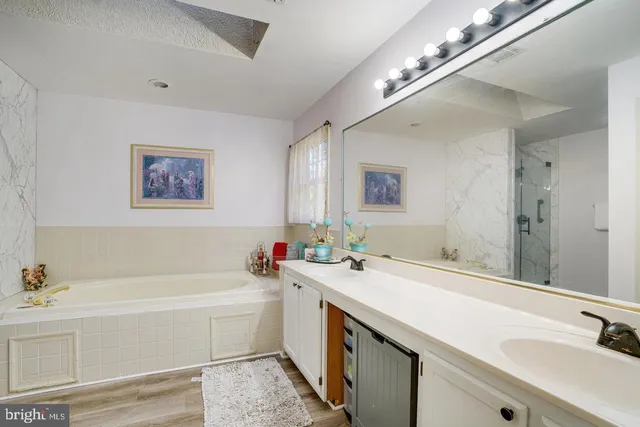 a bathroom with a tub a sink and mirror