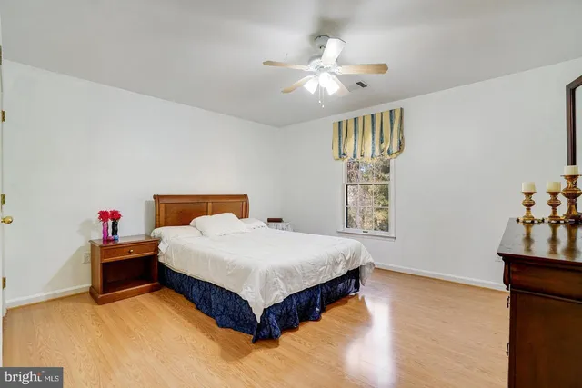 a spacious bedroom with a bed and a chandelier