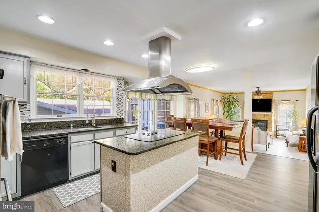 a kitchen with stainless steel appliances granite countertop sink stove and wooden floor